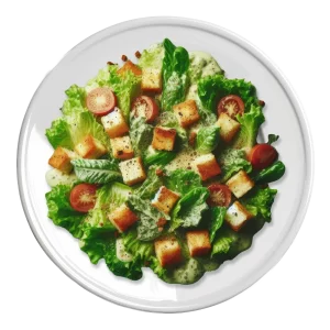 L'image montre une salade César composée de laitue romaine, de tomates cerises coupées en deux, de croûtons dorés, et parsemée de copeaux de fromage. La salade est généreusement nappée de sauce César, le tout présenté sur une assiette blanche.