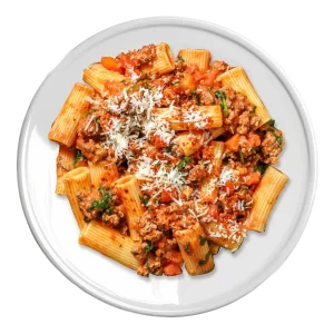 L'image montre une assiette de rigatoni à la bolognaise, garnie de fromage râpé.